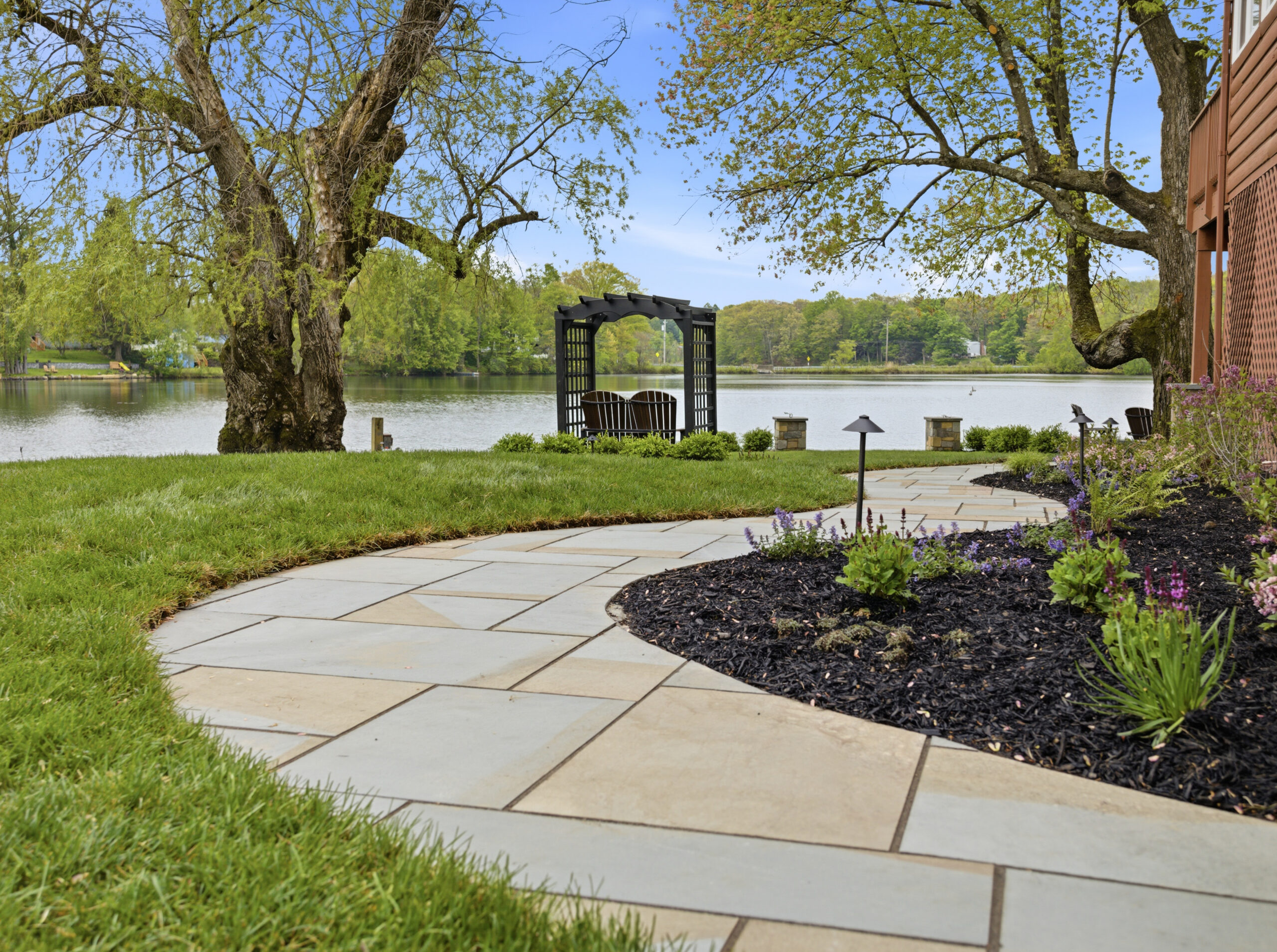 Curved bluestone path with arbor and lake view