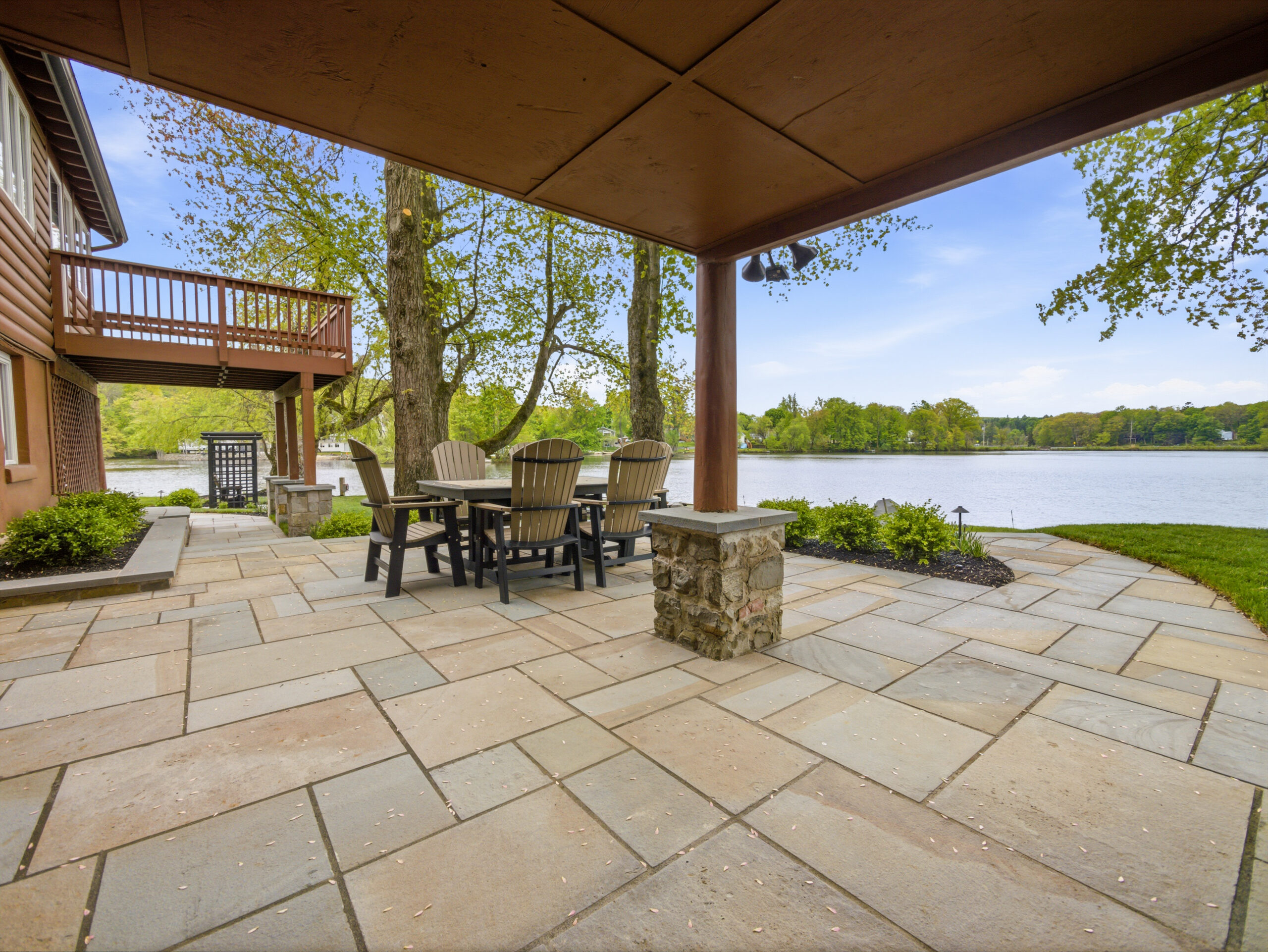 Covered lakeside patio with outdoor dining